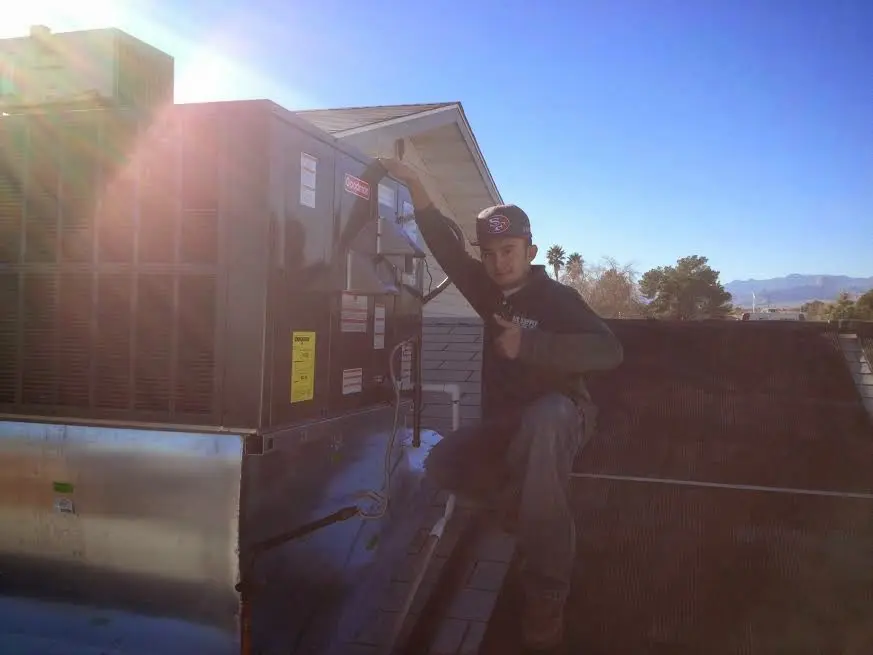 HVAC technician performing AC Tune-Up on a rooftop unit in Lahaina